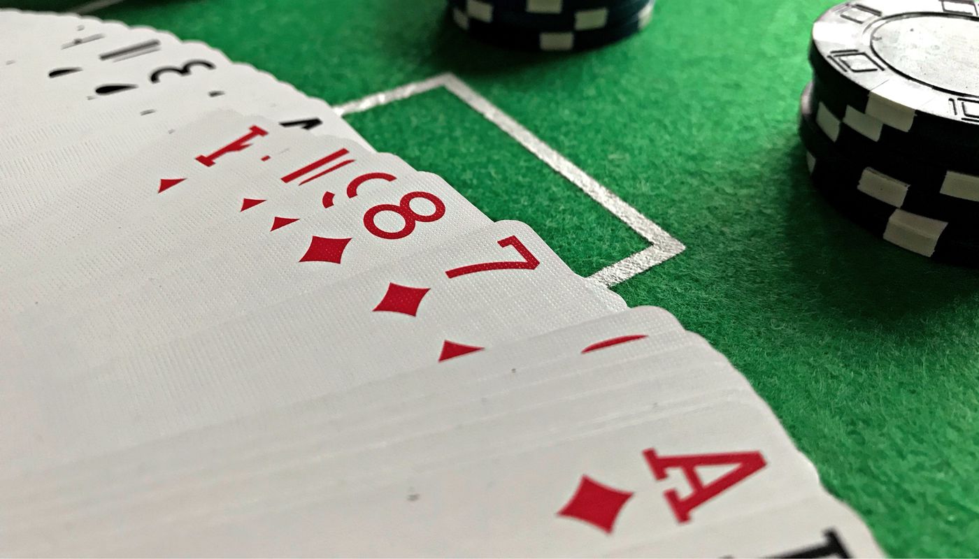 Close-up view of poker cards and chips on a green felt table, perfect for casino-themed content.